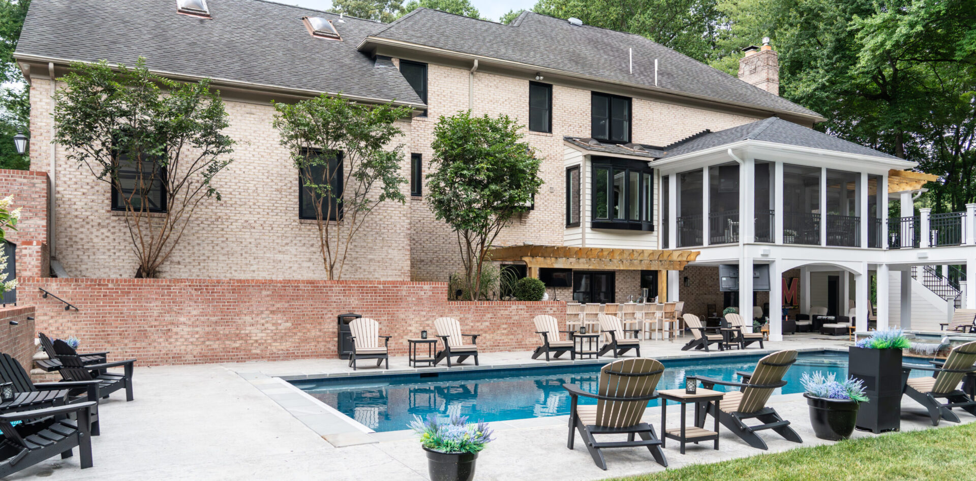 Back yard of brick home with pool featuring Vytex Potomac True Black windows.