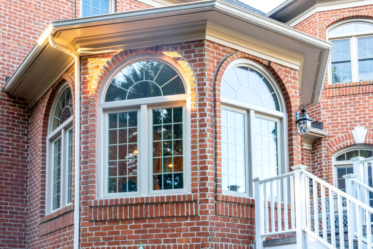 Brick home with beige windows. Click to explore our Fortis window series.